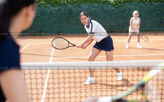 Young woman playing doubles tennis on court. Стоковое фото, фотограф Яков Филимонов / Фотобанк Лори