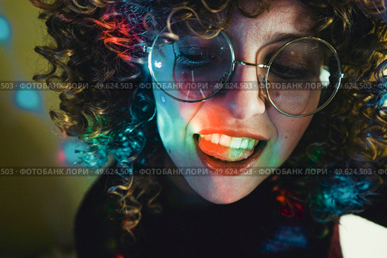 Young woman portrait illuminated by psychedelic lights. Стоковое фото, агентство Ingram Publishing / Фотобанк Лори