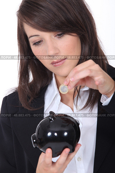 Young woman putting euros into a piggy bank. Стоковое фото, агентство Ingram Publishing / Фотобанк Лори