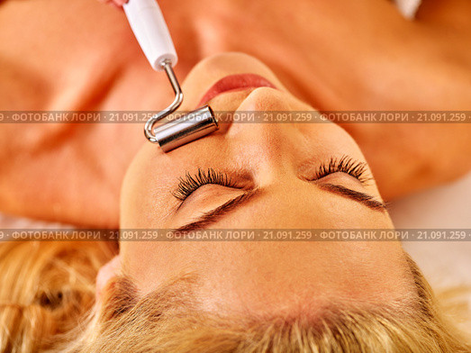 Young woman receiving electric facial massage. Стоковое фото, фотограф Gennadiy Poznyakov / Фотобанк Лори