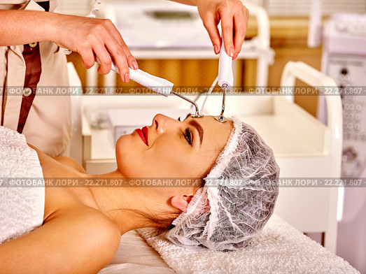 Young woman receiving electric facial massage. Стоковое фото, фотограф Gennadiy Poznyakov / Фотобанк Лори
