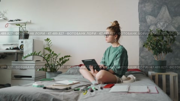 Young woman studying online course, writing down insights on tablet. Self-paced learning allows flexibility and better knowledge retention. Concept of digital education and self-improvement. Стоковое видео, видеограф Енваев Андрей / Фотобанк Лори