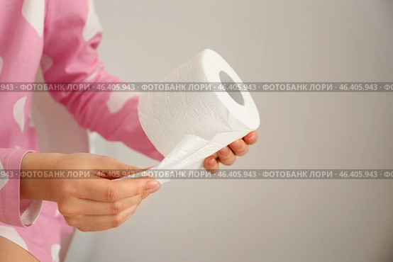 Young woman tearing soft toilet paper in restroom. Стоковое фото, фотограф Pixel_shot / Фотобанк Лори