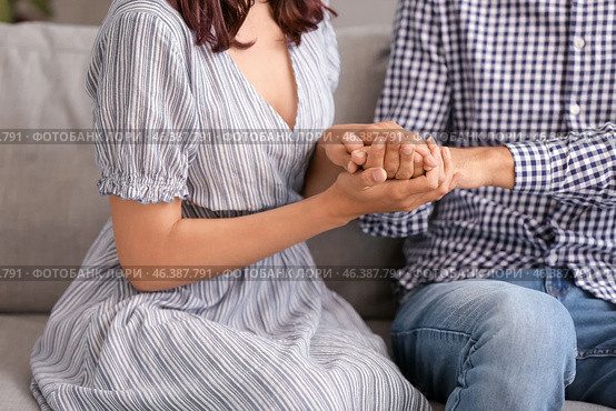 Young woman trying to make peace with husband after quarrel at home. Стоковое фото, фотограф Pixel_shot / Фотобанк Лори