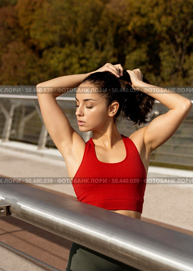 young woman tying her hair up. Стоковое фото, агентство Ingram Publishing / Фотобанк Лори