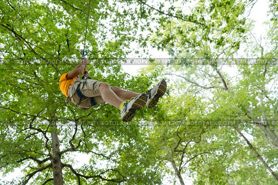 young woman zip-lining during tree top adventure. Стоковое фото, агентство Ingram Publishing / Фотобанк Лори