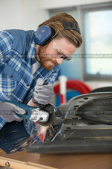 young worker with earmuffs in noise cancelling concept. Стоковое фото, агентство Ingram Publishing / Фотобанк Лори