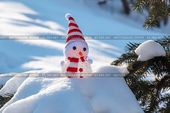 Забавный игрушечный снеговик на заснеженном фоне. Крупный план.  Funny toy snowman on snowy background. Close-up. (2022 год). Редакционное фото, фотограф Лариса Гордеева / Фотобанк Лори