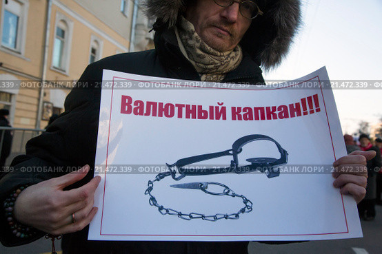 Заемщик валютной ипотеки участвует в протесте против политики банков во время шествия КПРФ по улице Петровка в центре города Москвы, Россия (2015 год). Редакционное фото, фотограф Николай Винокуров / Фотобанк Лори