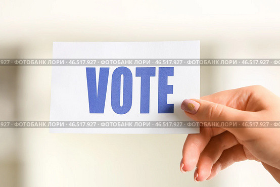 Женщина держит бумагу с текстом VOTE на избирательном участке, крупным планом. Стоковое фото, фотограф Pixel_shot / Фотобанк Лори