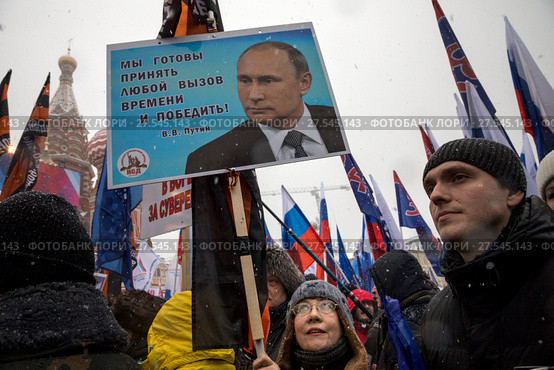 Женщина держит плакат с портретом президента РФ Владимира Путина во время митинга-концерта "Россия в моем сердце!" на Васильевском спуске в центр города Москвы, Россия, 3 февраля 2018. Редакционное фото, фотограф Николай Винокуров / Фотобанк Лори