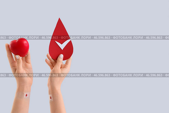 Женщина-донор крови с мячом для сжатия и бумагой на светлом фоне. Стоковое фото, фотограф Pixel_shot / Фотобанк Лори