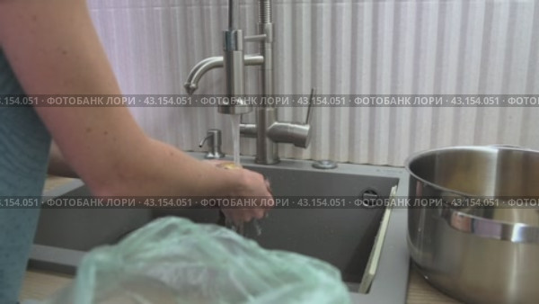 Женщина моет губкой картошку в воде и складывает ее в кастрюлю. Стоковое видео, видеограф Вячеслав Александров / Фотобанк Лори