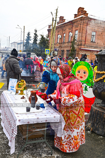 Женщина предлагает горячий чай из самовара. Масленица. Город Ялуторовск Тюменская область. Редакционное фото, фотограф Александр Тараканов / Фотобанк Лори
