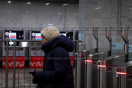 Женщина проходит турникеты в на входе на станцию Московского метрополитена в городе Москве, Россия (2023 год). Редакционное фото, фотограф Николай Винокуров / Фотобанк Лори