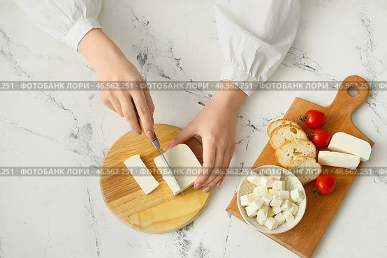Женщина режет вкусный сыр фета на столе. Стоковое фото, фотограф Pixel_shot / Фотобанк Лори