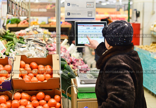 Женщина взвешивает продукты в  магазине (2017 год). Редакционное фото, фотограф Юрий Морозов / Фотобанк Лори